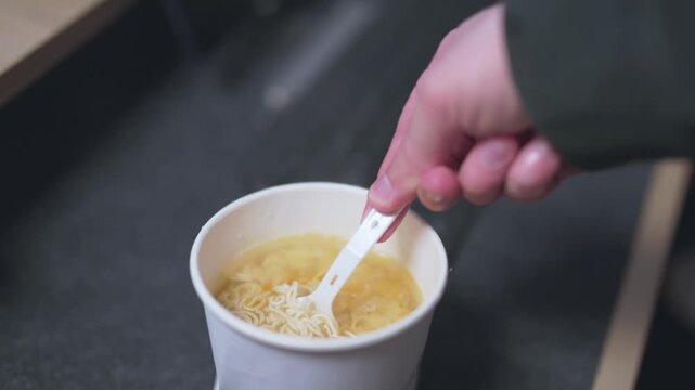 Close-up of pouring hot water into an instant noodle box