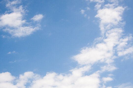 Blue sky background with white fluffy cumulus and stratocumulus clouds on a clear day, offering a feeling of freedom, space, and a bright future