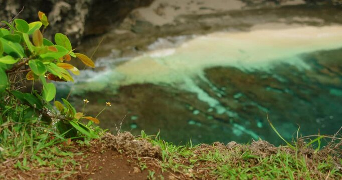 Top down view steep cliff overlooking sandy beach turquoise water rock bottom cove