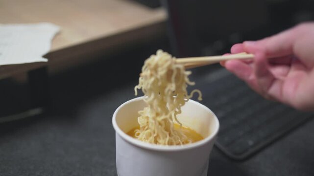 Close-up of pouring hot water into an instant noodle box