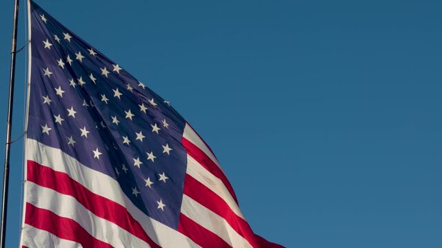 Slow Motion American Flag Waving with Copy Space Against Blue Sky
