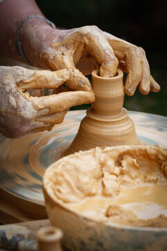 Hands shaping wet clay on a potter's wheel - France