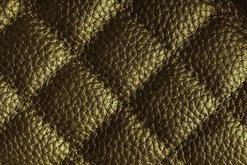 Fototapeta premium Close up, macro of khaki quilted leather texture with stitched diamond pattern, luxury material surface shining metal effect for fashion, upholstery or design wallpaper, rough, relief background