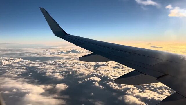 Airplane wing soaring through the clouds.