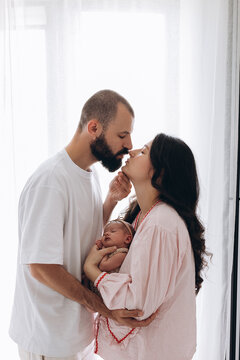 Family sharing tender moment with newborn in soft natural light