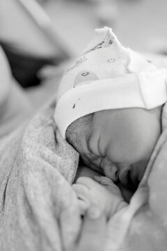 Newborn baby sleeps peacefully wrapped in soft blanket with gentle light around