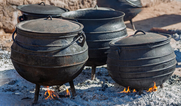 Traditional Cast Iron Three-Legged Cooking Pots Over Open Wood Fires traditional slow cooking.