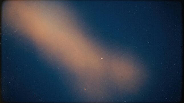 Vintage film texture with orange light leak and grain on dark blue background, ideal for cinematic website backgrounds, social media overlays, and professional presentation designs