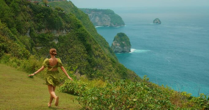 Woman traveler explores tropical paradise on scenic coastal trail in Bali Nusa Penida