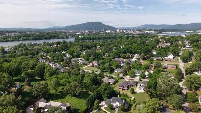 Aerial drone footage of the tree-lined streets in North Chattanooga, Tennessee, USA. Tree-lined residential streets, hillside homes, and scenic views near the Tennessee River. 