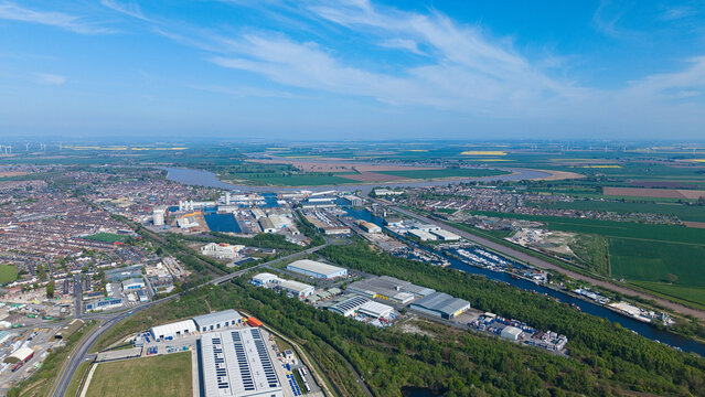 Aerial view of Goole docks, industrial warehouses, and the River Ouse surrounded by green fields and residential neighborhoods Goole, England, United Kingdom.