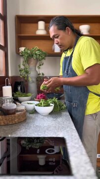 Adult man is preparing spinach in a kitchen for making Indonesian east java traditional salad named pecel