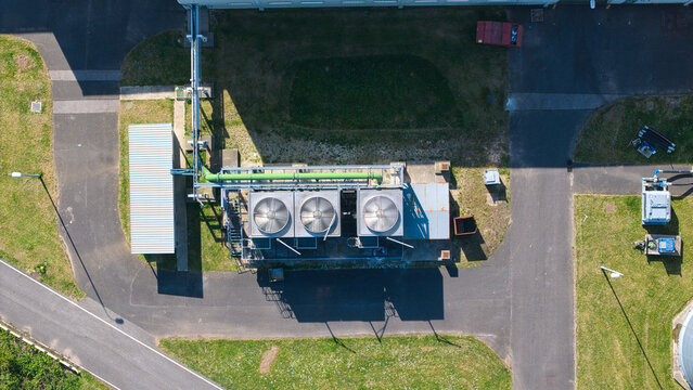 Aerial view of the industrial glass manufacturing facility featuring cooling units with large fans and metal piping Goole, England, United Kingdom.