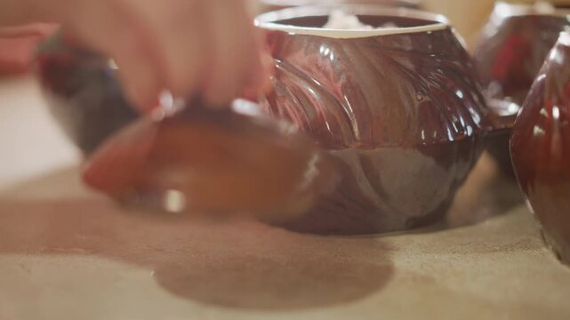 Sealing lid process. Ensuring proper sealing during meal preparation. Diligent chef secures lid to trap heat effectively. Cook meticulously seals pot to retain warmth and prevent steam escape