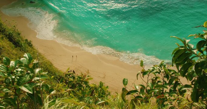 Overhead view of ocean waves washing on sand at Kelingking Beach Nusa Penida Bali