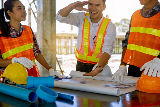 Structural engineer and architect and foreman worker with blueprints discuss, plan working for the building construction site office. Construction collaboration concept