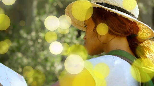 Woman wearing straw hat green pack turning, moving arm for travel as yellow bokeh drawing gaze