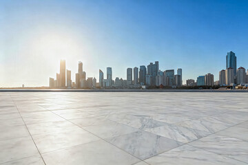 Obraz premium A wide empty marble paved plaza overlooks a modern downtown city skyline under clear sunny blue sky with warm morning sunlight.