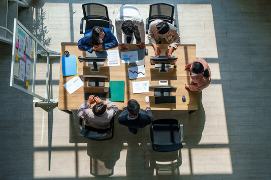 Business model marketing strategy ai teamwork meeting office data planning drive diverse team around table as leaders review chart laptop note and document from top view shaping growth plan with