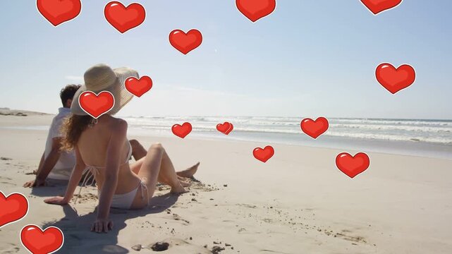 Couple sitting on shore, sunhat woman adjusting legs while animated red hearts appearing for travel