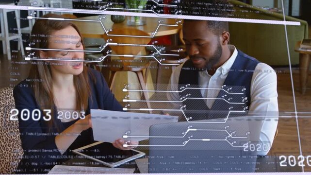 Woman presenting chart to man, both consulting devices as AR timeline guiding business review