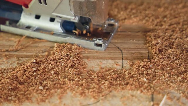 Closeup jigsaw cutting plywood surface, rich sawdust and focused blade movement, slow methodical carving across marked grain, tactile workshop atmosphere with warm wood tones and scattered shavings