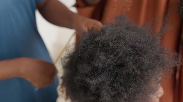 Hair styling with dedicated team. Dedicated professionals collaborate during bright professional hair session. Team of stylists carefully detangle and section textured hair in sunny studio environment