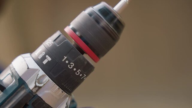 Closeup drill chuck with bit carpentry workshop showcasing precision woodworking, numbered torque ring, textured metal finish and subtle wear, warm studio lighting and shallow depth of field