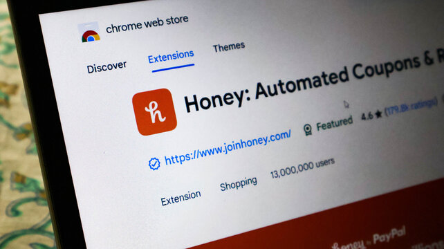 Closeup of a laptop screen displaying the chrome web store page for the honey browser extension, showing user count and rating