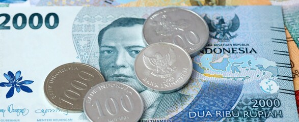 Indonesian rupiah money bills and coins on table. Indonesia cash of IDR currency © Larysa