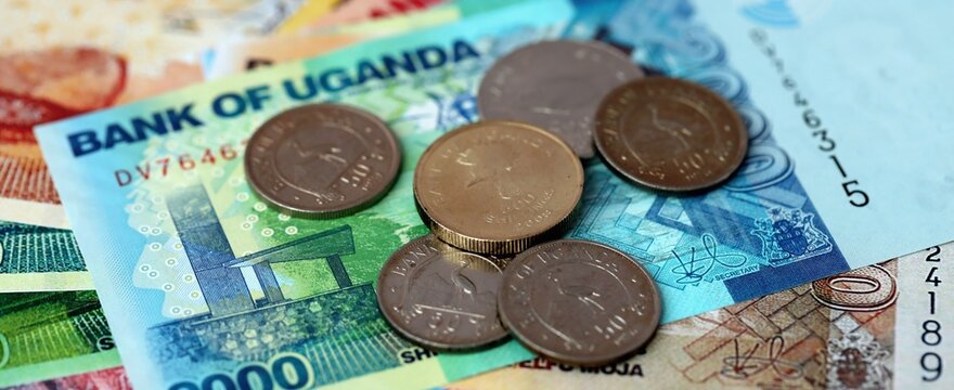Ugandan shilling money bills and coins on table. Uganda cash of UGX currency close up