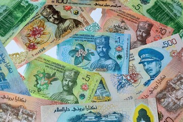 Brunei dollar money banknotes bunch on table. Brunei bills of BND currency close up © Larysa