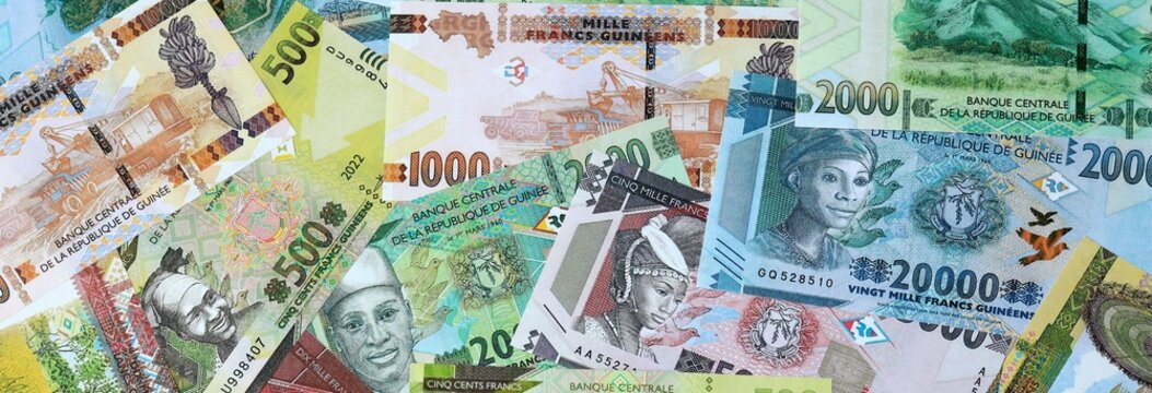 Guinean franc money banknotes bunch on table. Guinea bills of GNF currency close up
