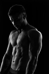 Fototapeta premium Gama, DF-Brasil – 04-29-2026: Athletic male torso with defined muscles and tattoos in dramatic black and white lighting