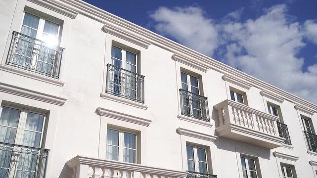 Charming white residence with reflective windows and ornate details