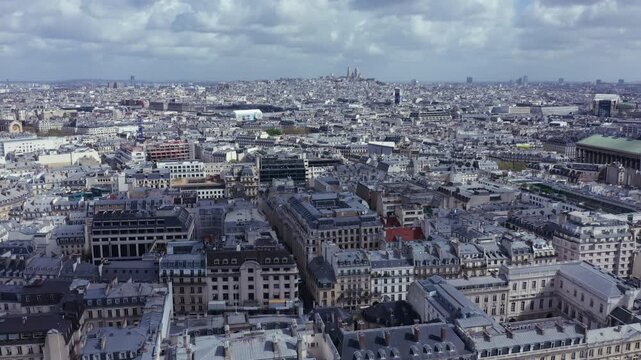 Aerial drone footage of Paris, France during the day, view of the city's iconic urban landscape. European architecture with dense rows of multi-story Haussmann style buildings