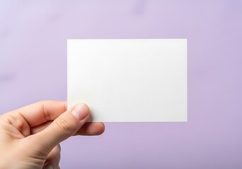 Fototapeta premium Hand Holding Blank White Card Against Purple Background
