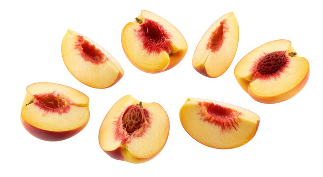 Several slices of fresh ripe peaches with pits arranged on a clean white background