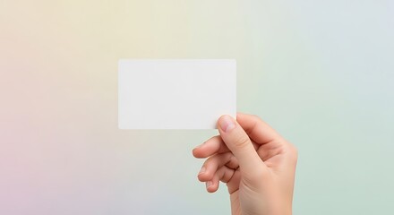 Fototapeta premium Hand holding blank white business card mockup on soft gradient background