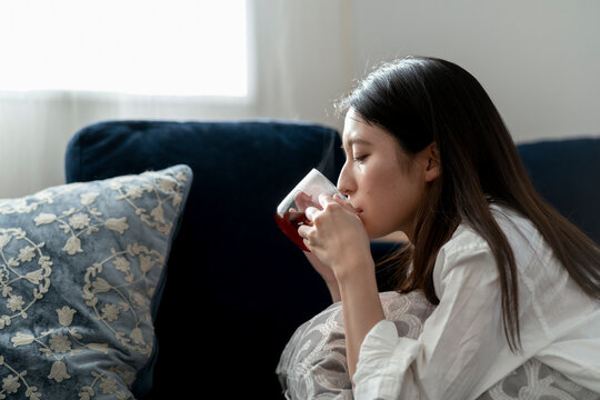 ホットドリンクを飲む若い日本人女性