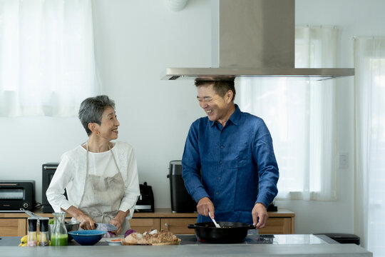 料理をする日本人シニア夫婦