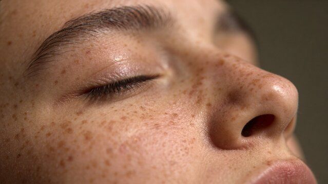 Close up woman face with beauty freckled skin with closed eye natural skin