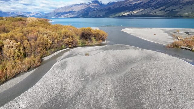 Aerial view of glenorchy river delta and turquoise lake wakatipu in autumn season southern alps new zealand.
