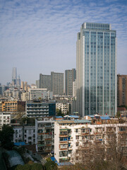 Naklejka premium Dense city skyline contrasting old low-rise residential blocks with modern glass skyscrapers