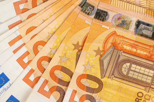 Macro detail of euro banknotes arranged in fan suggesting payment transaction or cash exchange, clear numerals and edge patterns create dynamic commerceoriented composition