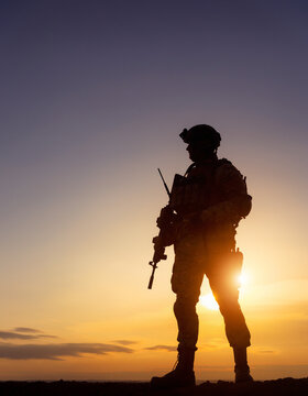 Soldier Silhouette Standing Strong at Sunrise with a Rifle