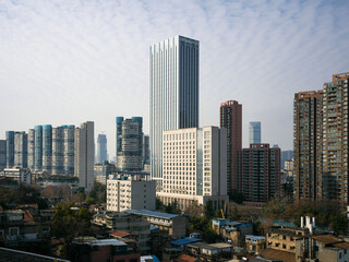 Wide cityscape showing dense old residential rooftops contrasting with modern skyscrapers under cloudy sky © syu