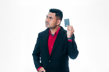 Naklejka premium Portrait of an Indonesian professional man in a suit looking pensive while holding a credit card, isolated on white background. 