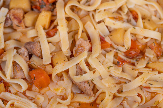 Traditional Central Asian homemade lagman showcasing handcut noodles, stewed meat, potato and carrot medley authentic spice hints and cultural comfortfood presentation