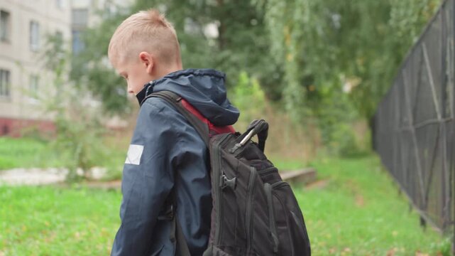 Caregiver calms youngster. Adult assures anxious young boy. Mother comforts son facing first school day. Respective guardian offers comfort and reassurance to hesitant young student outside school